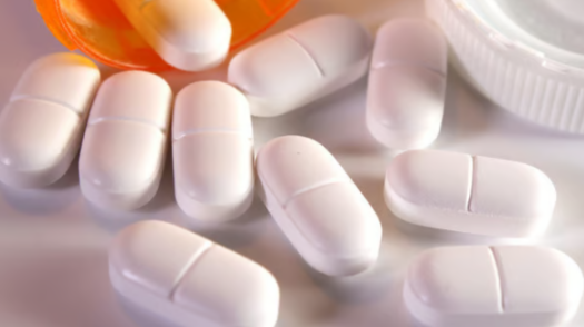 Close up on a plate of mashed potatoes, topped with baked pork chops with cream of mushroom soup, and a side of green beans.