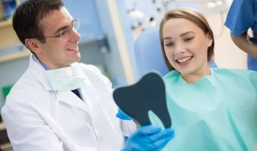 Close up on a plate of mashed potatoes, topped with baked pork chops with cream of mushroom soup, and a side of green beans.